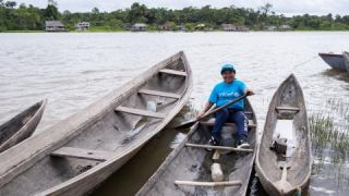 María Torres, consultora de la comunidad indígena Warao, sonríe a la cámara sobre una curiara (bote artesanal) en el Río Orinoco, San Francisco de Guayo en el estado de Delta Amacuro, el 21 de marzo de 2023.